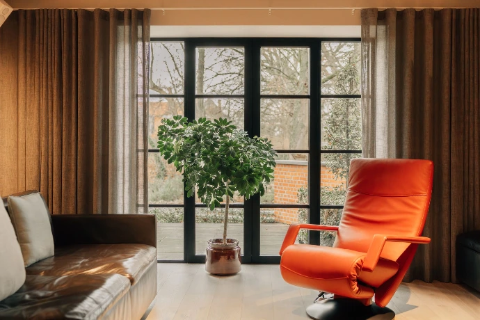 Interieur met oranje stoel en metalen deur naar buiten